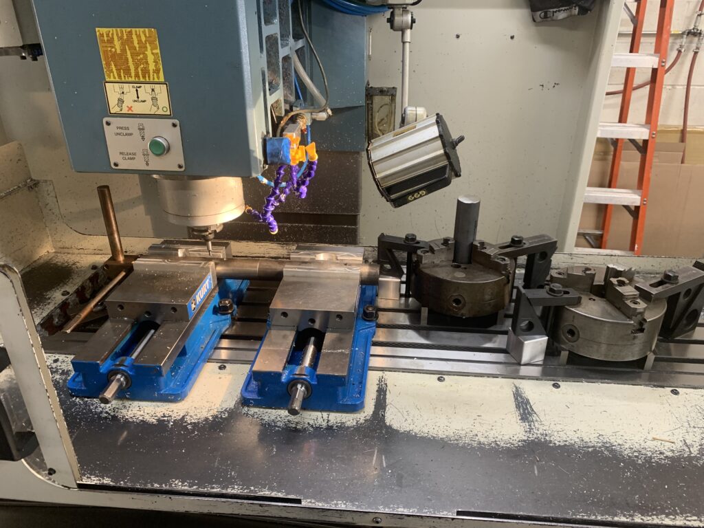 CNC mill table with vises and fixtures set up for a job
