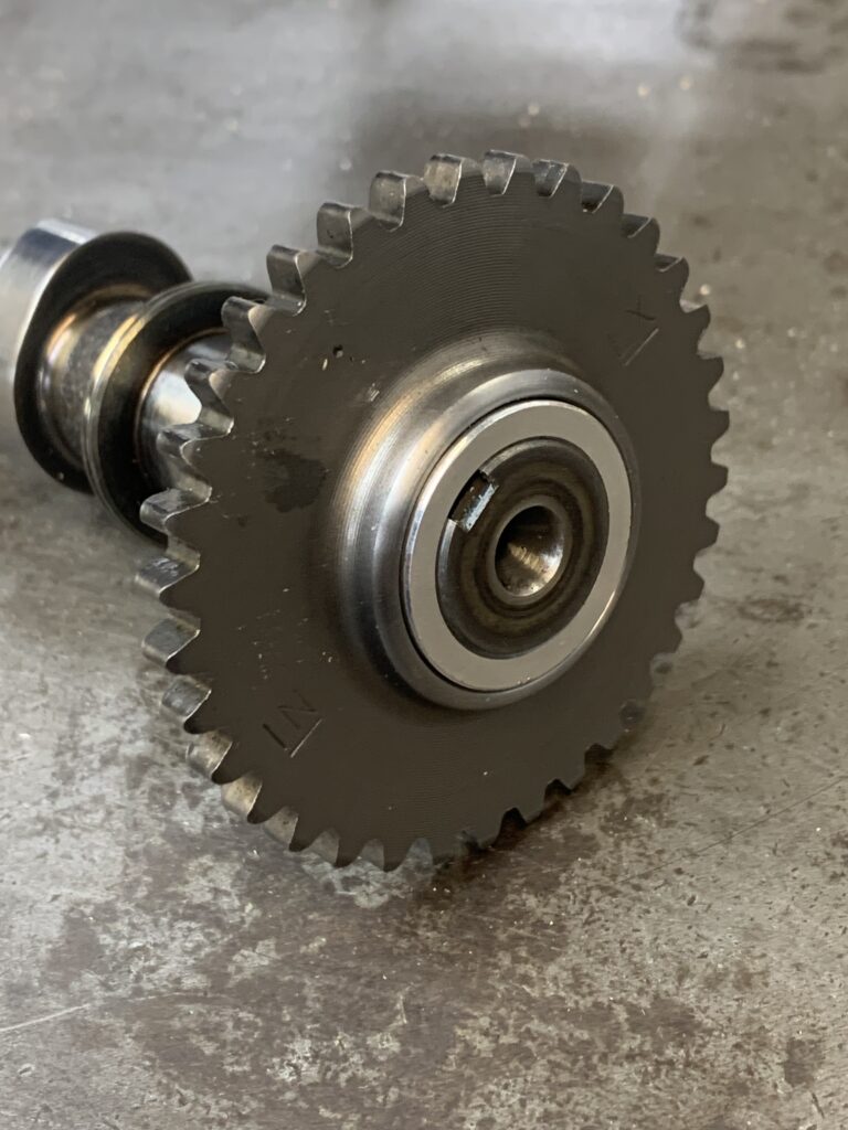 Custom machined cam gear on a shaft at Nitro Custom Works